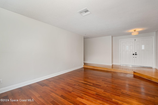 empty room featuring a textured ceiling and hardwood / wood-style flooring