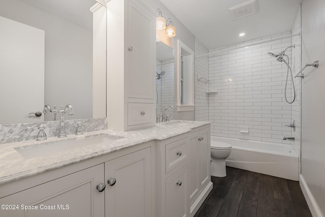 full bathroom featuring wood-type flooring, toilet, vanity, and tiled shower / bath