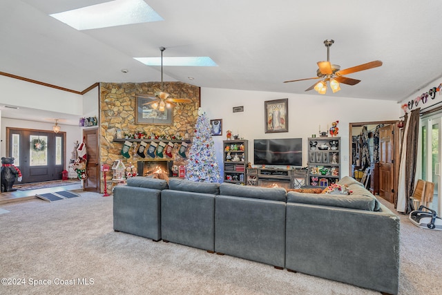 carpeted living room with vaulted ceiling with skylight, plenty of natural light, and ceiling fan