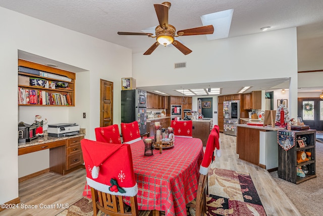 dining room featuring ceiling fan, a textured ceiling, and light wood-type flooring