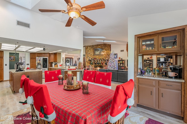 dining room with light wood-type flooring, ceiling fan, and lofted ceiling