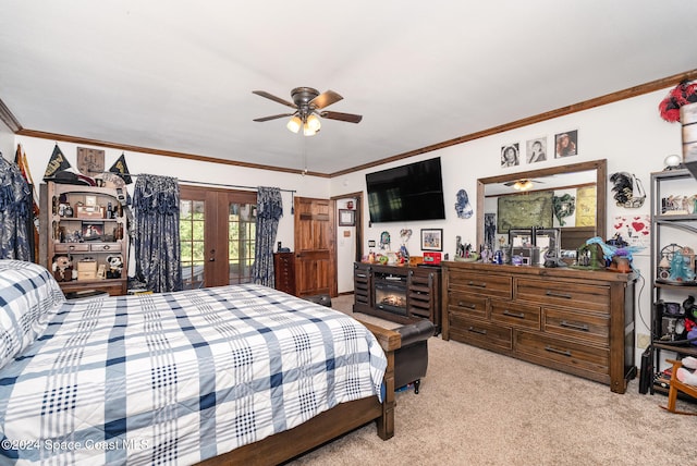 carpeted bedroom featuring access to exterior, french doors, ceiling fan, crown molding, and a fireplace