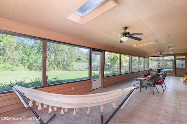 sunroom / solarium featuring ceiling fan and a skylight