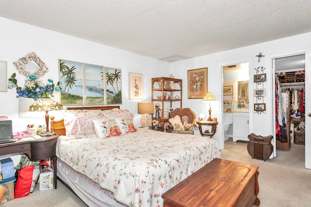 bedroom with ensuite bath, light carpet, a spacious closet, and a closet