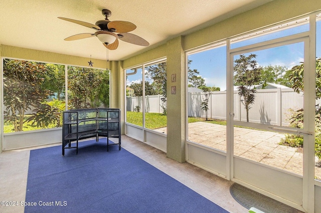 unfurnished sunroom with ceiling fan