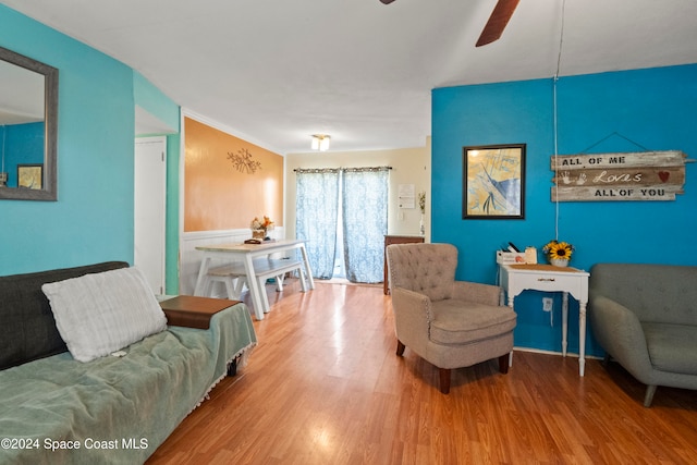 living room with hardwood / wood-style flooring, ceiling fan, and ornamental molding