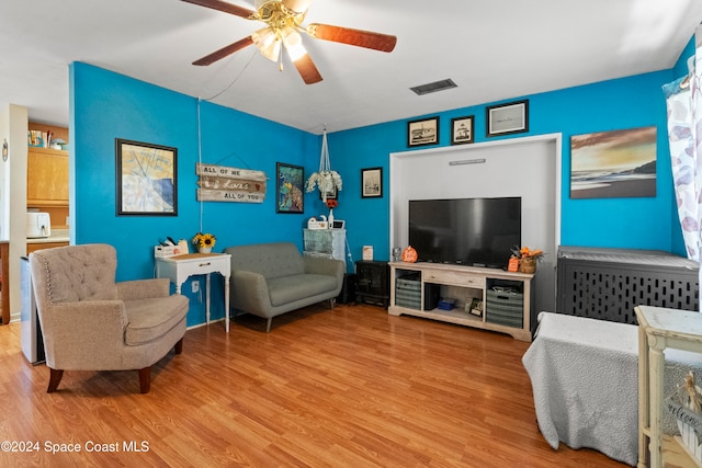 living room with light hardwood / wood-style floors and ceiling fan