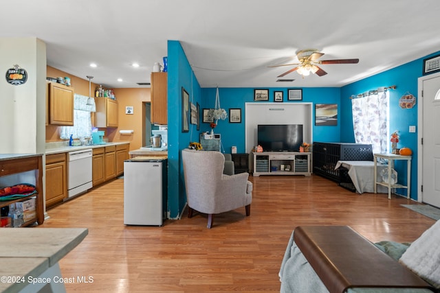 living room featuring ceiling fan, plenty of natural light, and light hardwood / wood-style floors