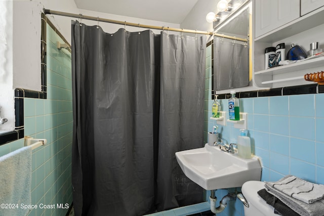 bathroom featuring sink, tile walls, and walk in shower