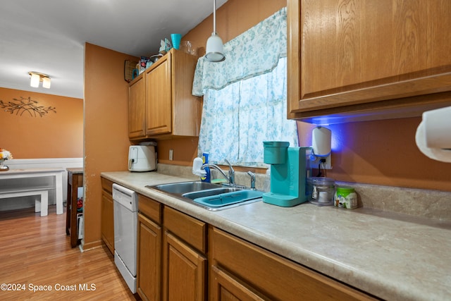 kitchen featuring dishwasher, pendant lighting, light wood-type flooring, and sink