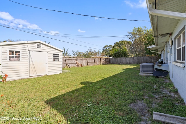 view of yard with central AC and a storage shed