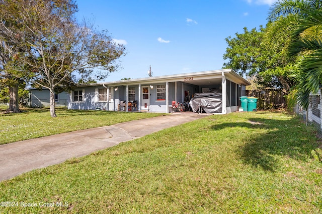 view of front of property with a carport and a front lawn