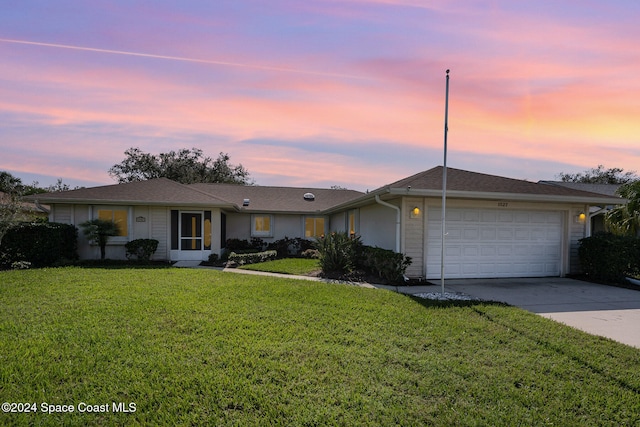 ranch-style home with a yard and a garage