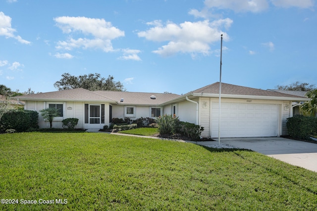 single story home featuring a garage and a front lawn