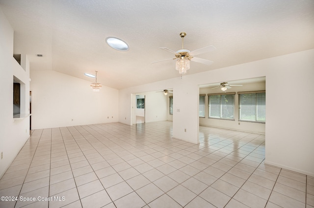 tiled spare room featuring vaulted ceiling, ceiling fan, and a textured ceiling