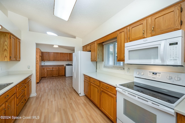 kitchen with lofted ceiling, washer / clothes dryer, white appliances, and light hardwood / wood-style flooring