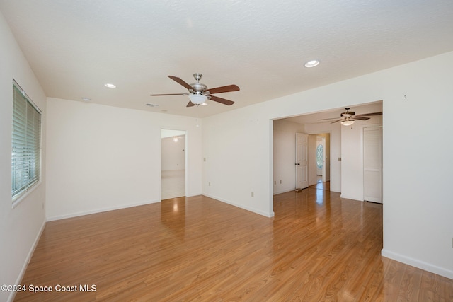 unfurnished room with ceiling fan, light hardwood / wood-style floors, and a textured ceiling