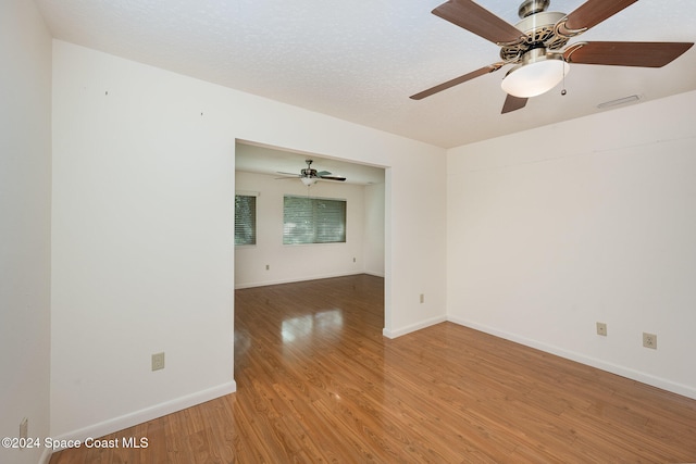 unfurnished room with hardwood / wood-style floors and a textured ceiling