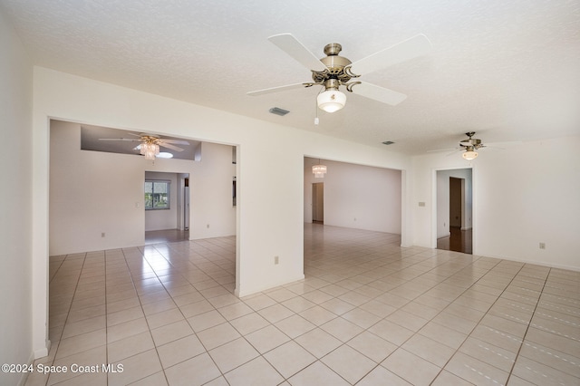 tiled spare room with ceiling fan and a textured ceiling