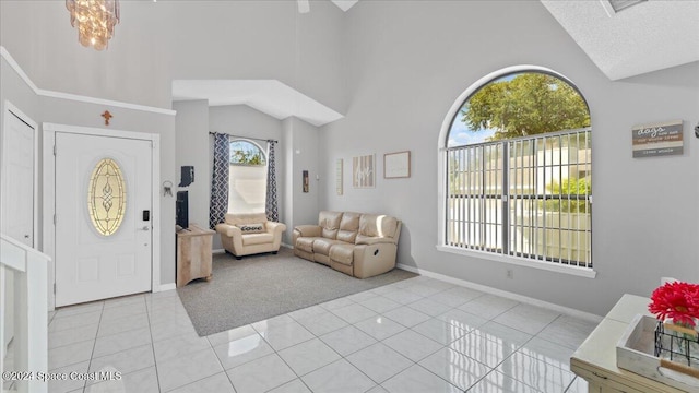 foyer featuring high vaulted ceiling, plenty of natural light, a notable chandelier, and light tile patterned flooring