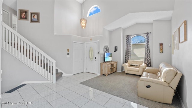 entryway with high vaulted ceiling and light colored carpet