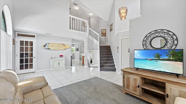 tiled living room with an inviting chandelier and high vaulted ceiling