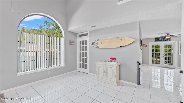 tiled foyer entrance featuring a textured ceiling, french doors, and ceiling fan