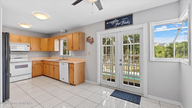 kitchen with french doors, a healthy amount of sunlight, white appliances, and sink