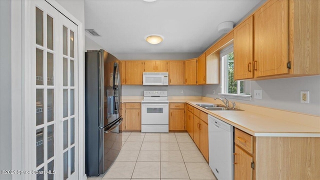 kitchen featuring light tile patterned floors, white appliances, and sink