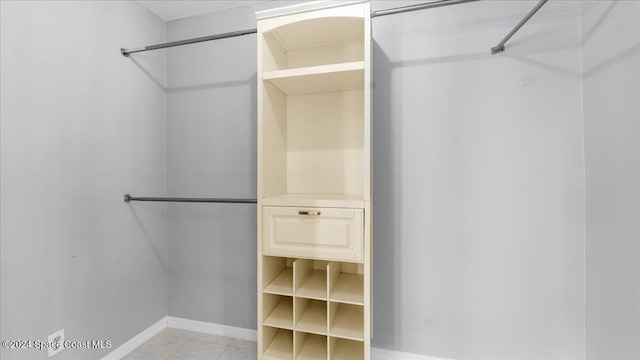 walk in closet featuring light tile patterned flooring