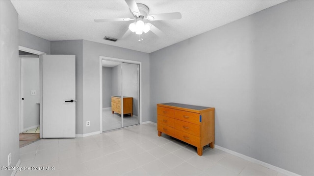 bedroom featuring a closet, a textured ceiling, and ceiling fan