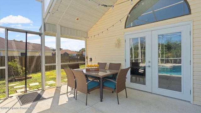 sunroom / solarium featuring french doors and vaulted ceiling