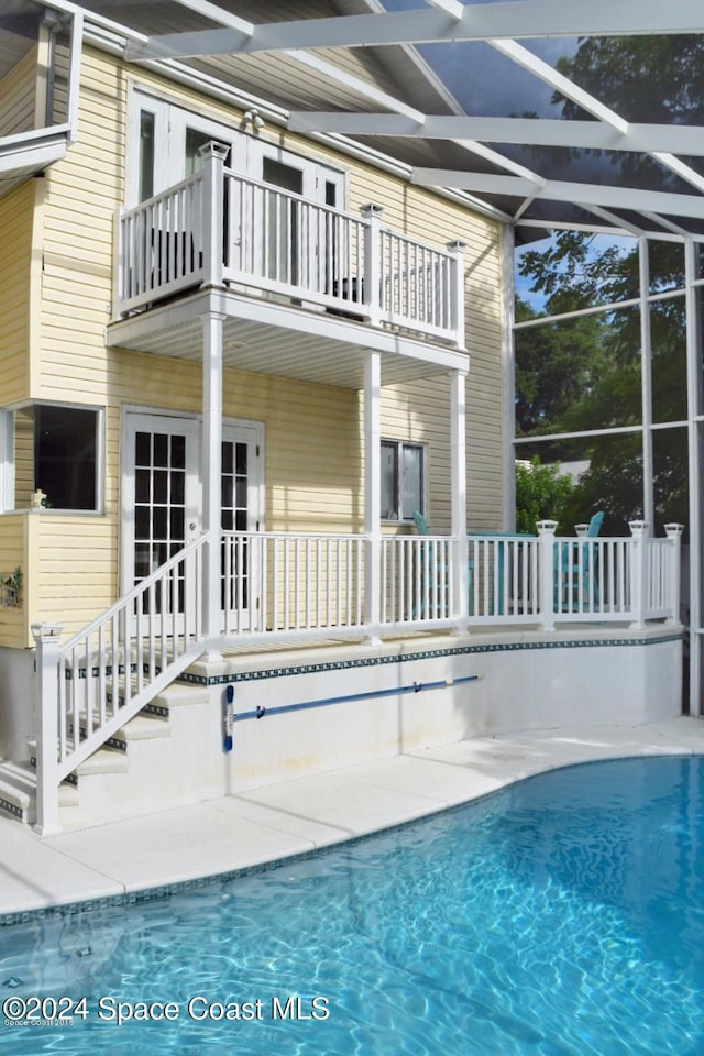 view of swimming pool with a lanai and french doors