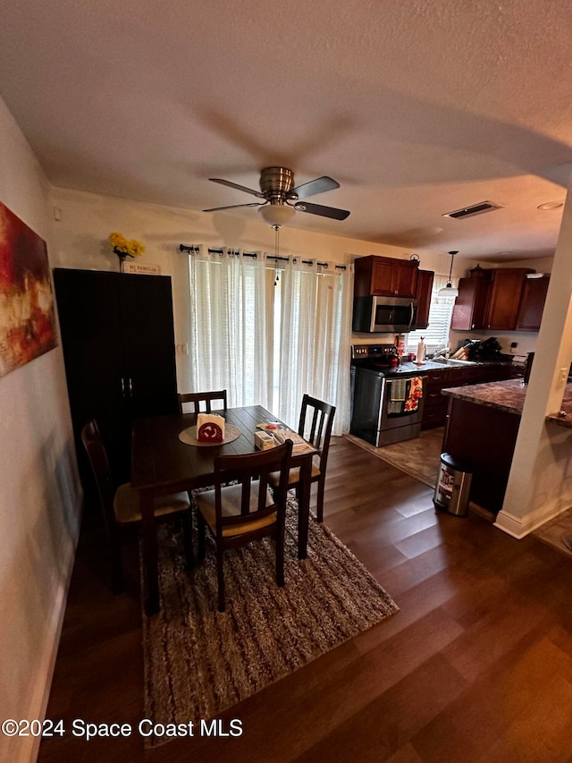 dining area featuring a textured ceiling, dark hardwood / wood-style floors, and ceiling fan