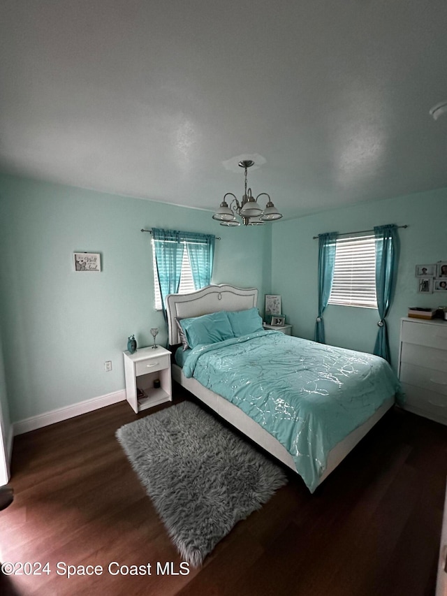 bedroom featuring a chandelier and dark hardwood / wood-style flooring