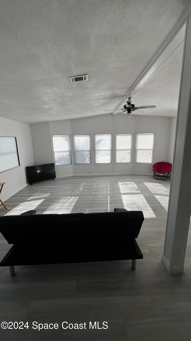 unfurnished living room featuring a textured ceiling and ceiling fan