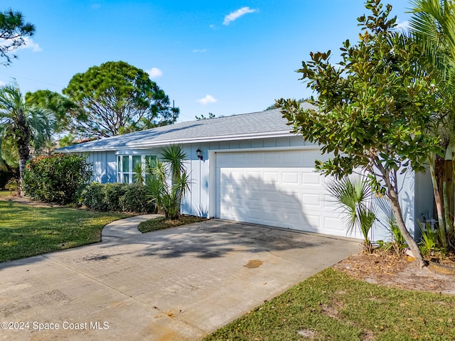 ranch-style home with a garage and a front lawn