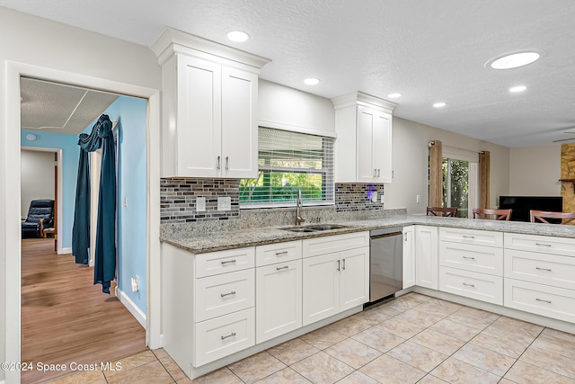 kitchen featuring dishwasher, sink, a healthy amount of sunlight, and a textured ceiling