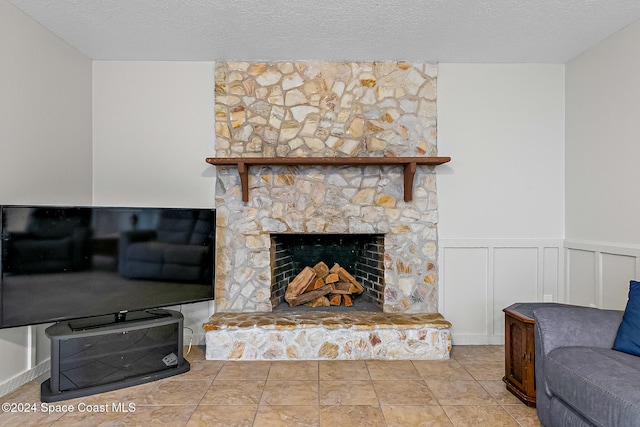 living room with a textured ceiling and a fireplace