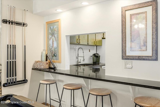 kitchen with backsplash, sink, and a kitchen breakfast bar