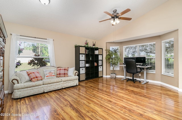 office featuring ceiling fan, light wood-type flooring, a textured ceiling, and high vaulted ceiling