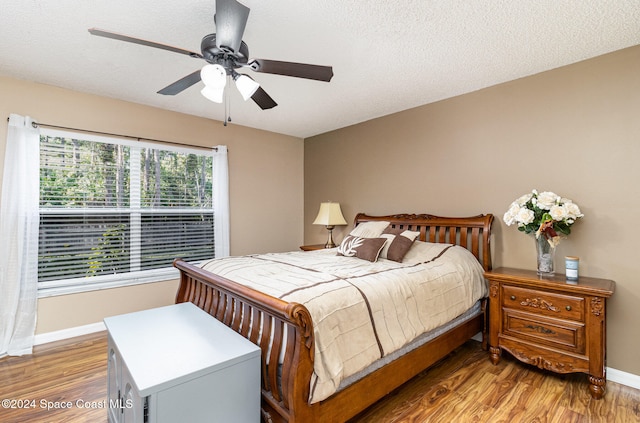 bedroom featuring a textured ceiling, light hardwood / wood-style flooring, and ceiling fan