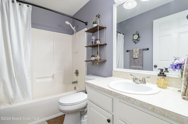 full bathroom featuring vanity, tile patterned floors, toilet, shower / bath combo with shower curtain, and a textured ceiling