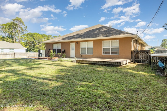 back of house with a lawn, a wooden deck, and central AC unit