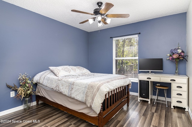 bedroom with a textured ceiling, ceiling fan, and dark wood-type flooring