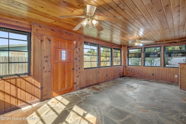 entrance foyer featuring wood walls, ceiling fan, and wooden ceiling