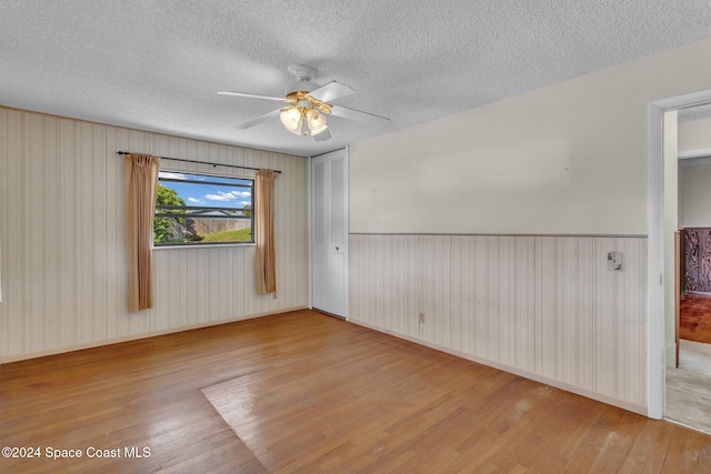 unfurnished room with light hardwood / wood-style floors and a textured ceiling