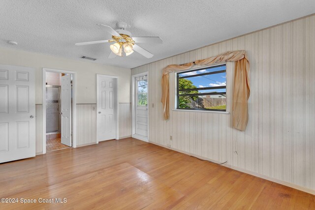 unfurnished bedroom featuring ceiling fan, wood-type flooring, and a textured ceiling