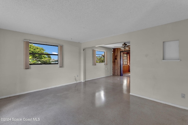 unfurnished room with ceiling fan, a textured ceiling, and a healthy amount of sunlight