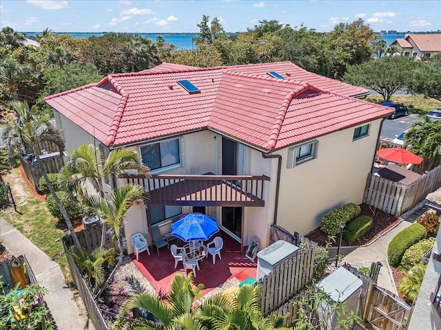 exterior space with a balcony, a patio, and a water view